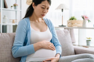 Schwangere Frau ist besorgt, da ihr Bauch hart ist.
