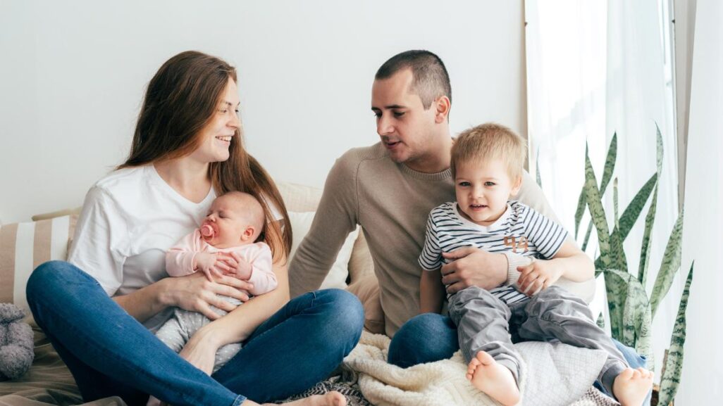 Familie mit Kleinkind und Baby im Arm