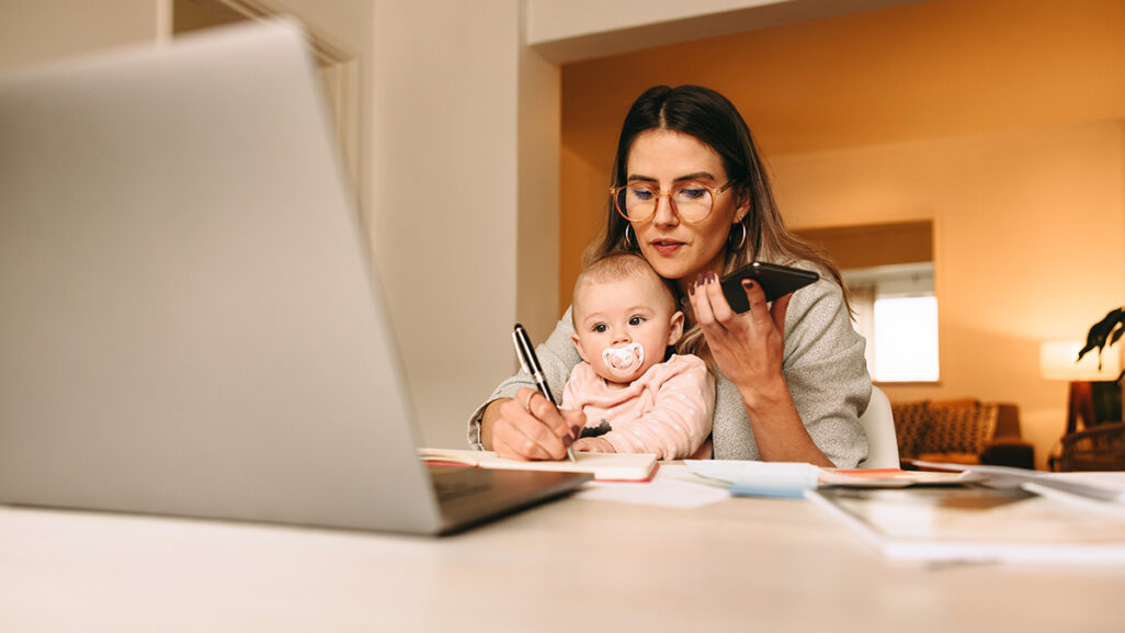 Mutter arbeitet mit Baby auf dem Schoß