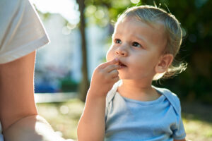 Mutter und Baby sitzen auf einer Wiese und essen Baby Snacks