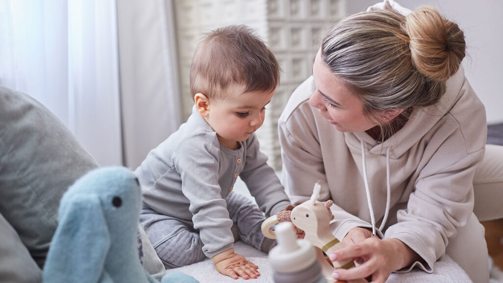 Baby spielt mit seiner Mama und dem Spielzeug