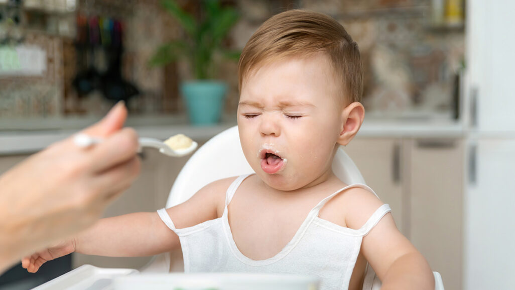 Baby wird gefüttert und verzieht angeekelt das Gesicht